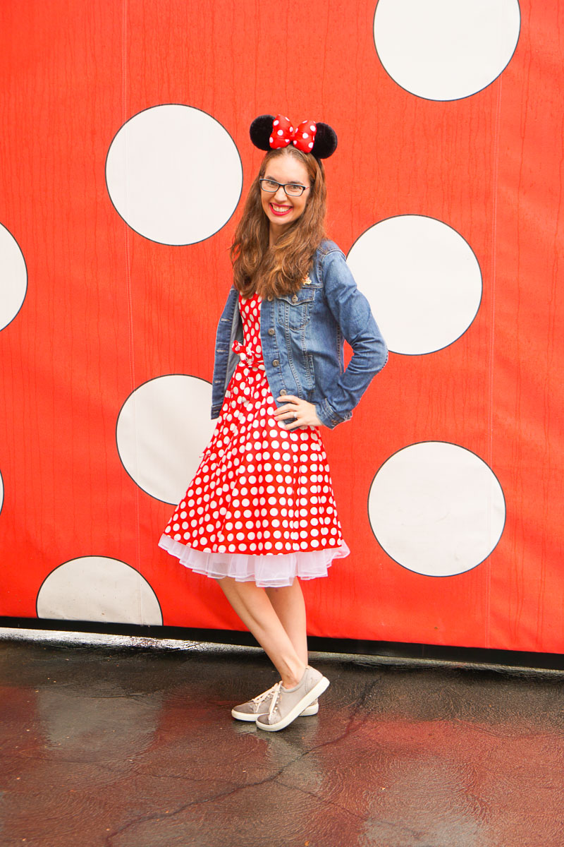What to Do at Disneyland in the Rain, tips featured by top US Disney blogger, Marcie and the Mouse: A woman dressed in a red polka dot dress wearing Minnie ears standing in front of a polka dot wall at Disneyland