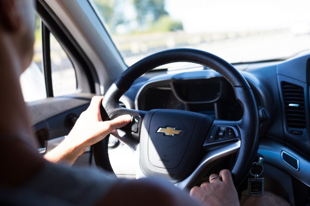 Image of a Chevrolet steering wheel with someone driving.